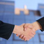 2 people shaking hands over an agreement.