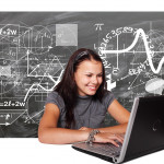 a student on a computer with a chalk board behind them